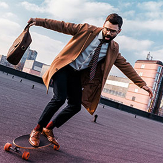 Mann in Anzug fährt Longboard